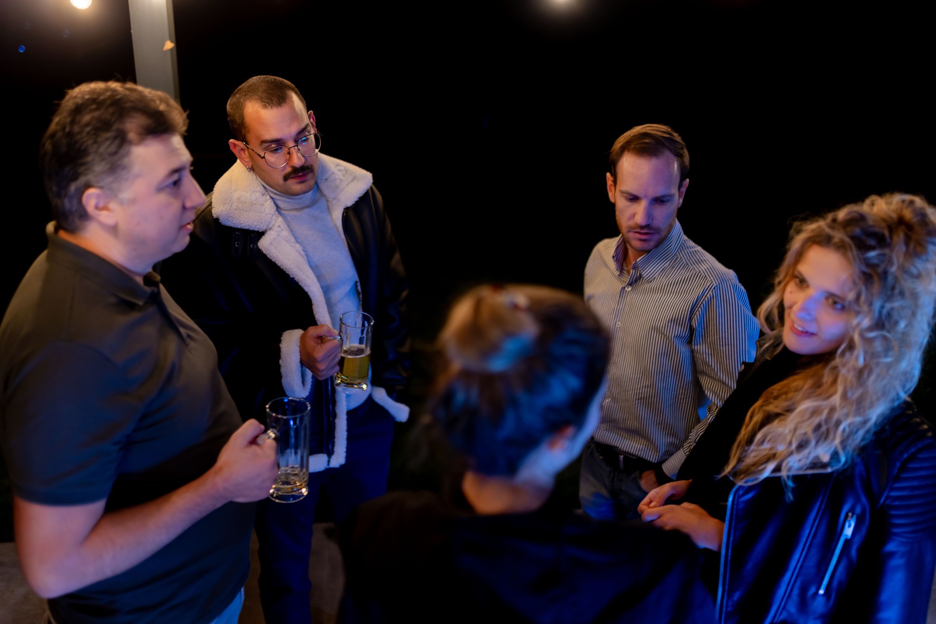 Group of friends enjoying casual conversation over drinks during an evening gathering